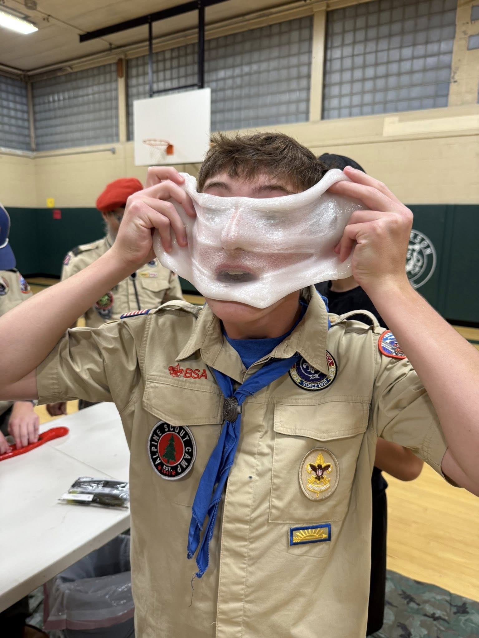 Scout in BSA uniform having fun with slime on their face